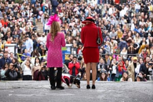 A woman introduces her dog to the crowd and judges.