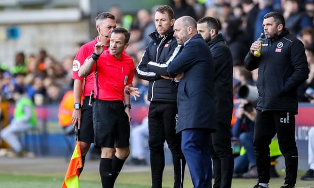 Referee Keith Stroud discusses alleged homophobic chants from the crowd with Millwall’s manager, Gary Rowett, and Reading’s Mark Bowen. 
