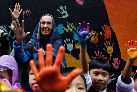 Goodall with children raising their hands, which are painted