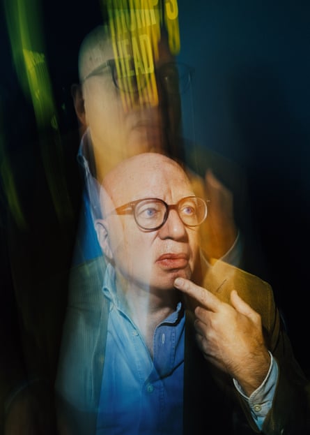 A man with glasses puts his finger on his chin
