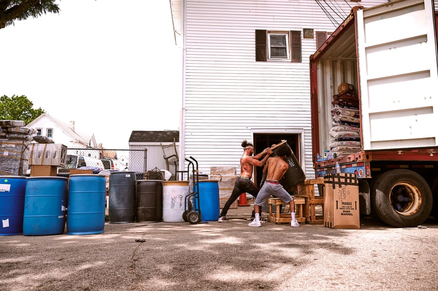 Men loading a truck with large bins.