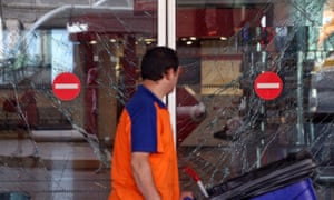 A worker walks past the broken windows from the blasts at Turkey’s largest airport.