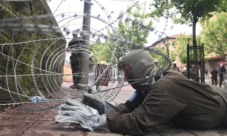 A soldier from the Austrian contingent of the Nato-led international peacekeeping force in Kosovo sets up a razor wire fence in front of a municipal building in Zvecan, Kosovo, on Wednesday,