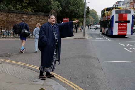 A rikishi tries to hail a cab near his hotel at Kensington Gardens.
