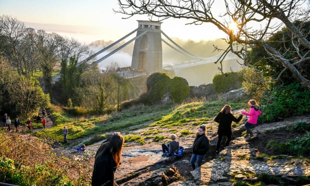 Children play on a natural slide formed in rock next to the Clifton Suspension Bridge in Bristol.