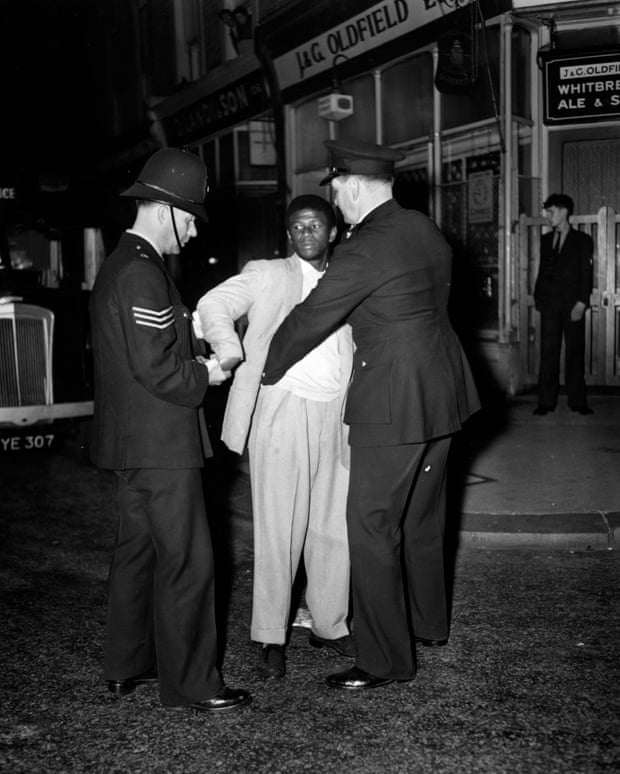 Police search a youth in Talbot Road, Notting Hill during race riots of 1958