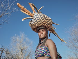 A woman balances a bundle of wood on her head