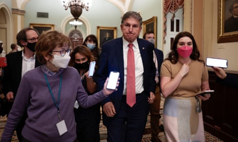 Joe Manchin is followed by reporters as he leaves a caucus meeting with Senate Democrats on Friday.