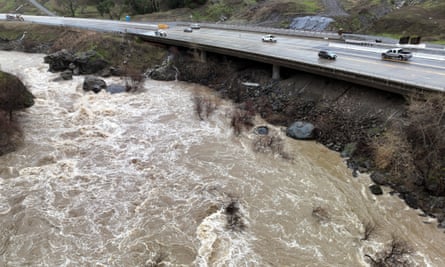 The Russian River, swollen with storm water, flows alongside Highway 101 in Hopland, California