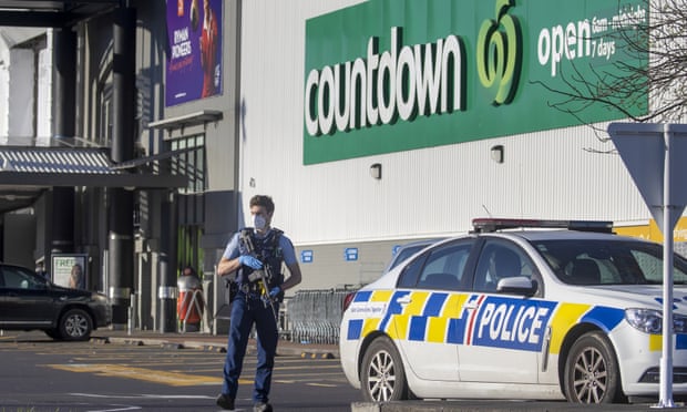 An armed policeman outside the supermarket in Auckland where a man stabbed several shoppers on Friday.