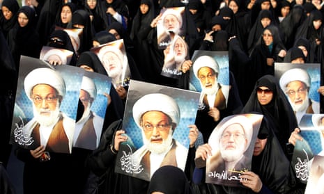 Anti-government protesters hold posters of Ayatollah Isa Qassim