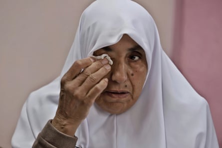 Aziza Mirie wipes away a tear as she speaks