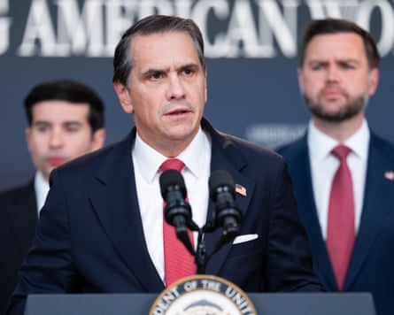 A man in a suit speaking at a lectern with the US seal on the front, with the US vice president behind him.
