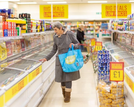 An older woman shopping in a discount supermarket.