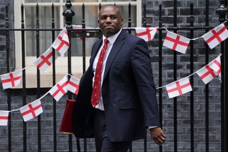 David Lammy outside No 10. England flag bunting is draped on the fence outside the property