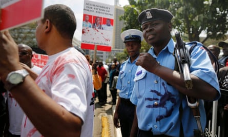 A police officer reacts after his uniform was smeared with a red handprint during the protest in Nairobi
