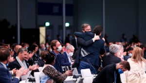 Brazil's top diplomat for climate negotiations, Paulino Franco de Carvalho Neto, embraces a climate negotiator during the closing plenary of Cop26