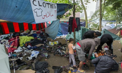 Asylum seekers search for clothes in a makeshift camp outside the foreign office in Brussels, Belgium