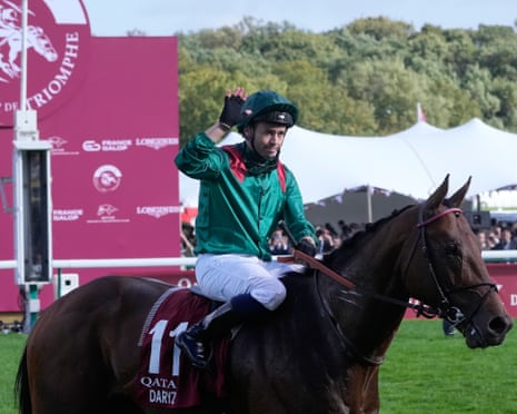 The French jockey Mickael Barzalona waves from astride his horse, Daryz, after winning the 2025 Prix de lâÂÂArc de Triomphe in Paris.
