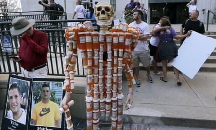 A skeleton of pill bottles with protesters outside a courthouse where a judge heard arguments in a lawsuit against Purdue Pharma in Boston, Massachusetts, on 2 August.