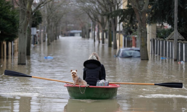 Paris residents and their dog take to the flood waters in a dinghy.