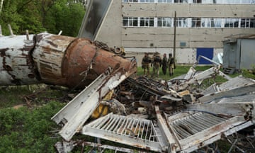 Police officers stand next to a part of a television tower partially destroyed by a Russian missile strike in Kharkiv, Ukraine, 22 April 2024.