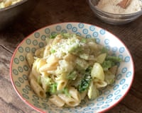 Bowl of Rachel Roddy's penne with potato, cabbage, butter and cheese on a bowl. On a table.