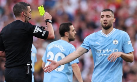 Mateo Kovacic is shown a yellow card by referee Michael Oliver.