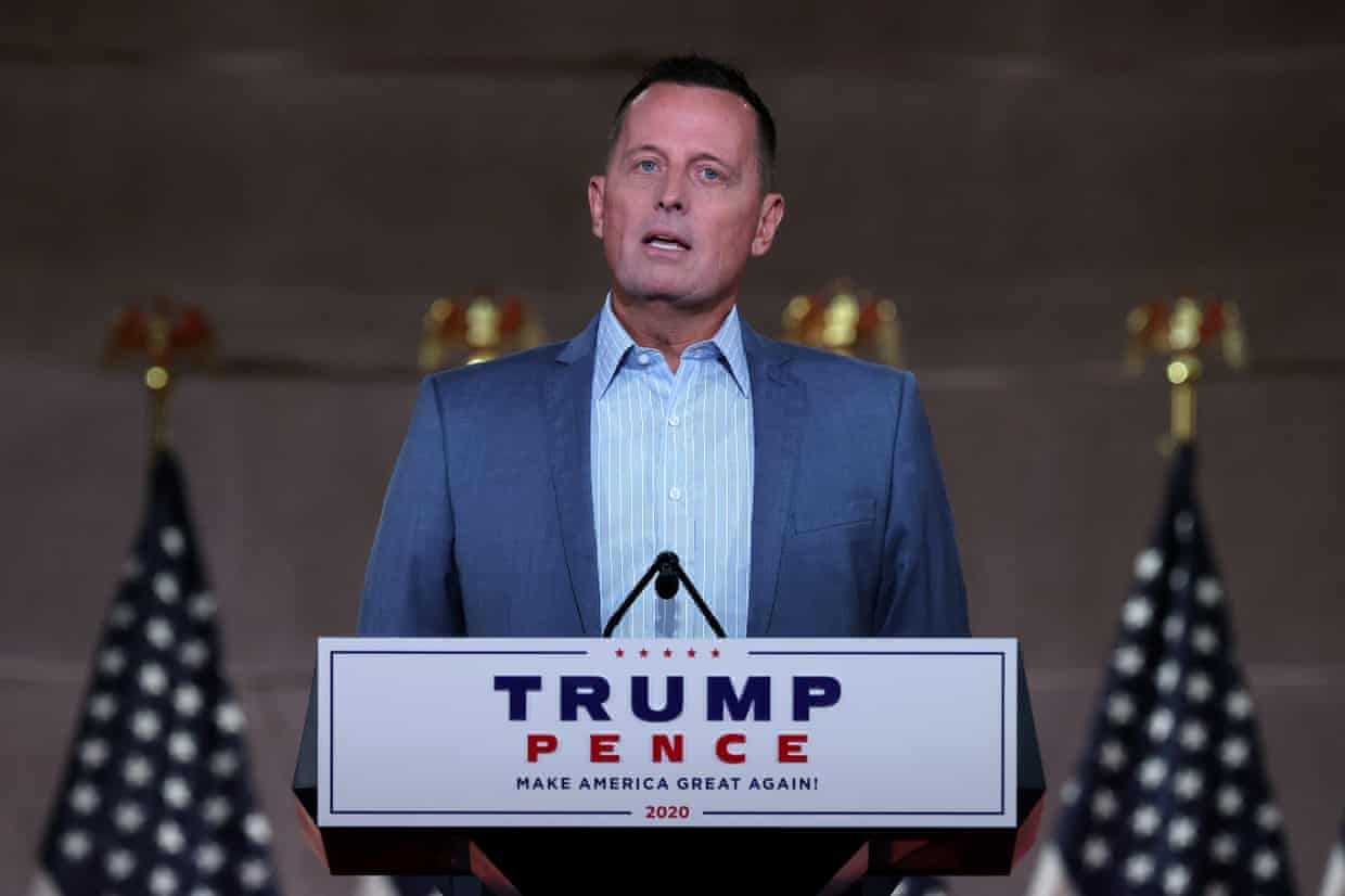 Richard Grenell speaks at a Trump-Pence podium flanked by American flags
