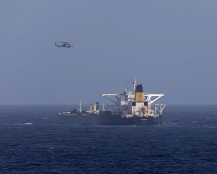 A US military helicopter flies over a Panama-flagged ship.