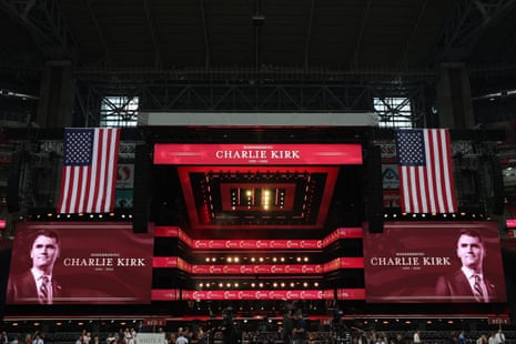 stage says 'remembering charlie kirk' with a picture of a man and american flags hanging