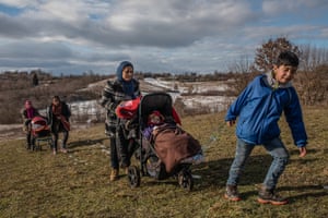 A family with small children in pushchairs walk the dangerous route to the Croatian border