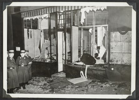 Nazis pose next to a vandalised shop.