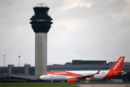 Bir uçak Manchester Havalimanı'ndaki kontrol kulesinin önünden geçiyor