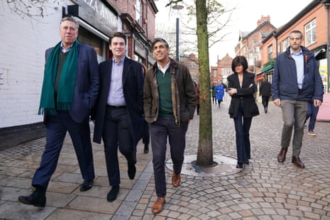 Sir Graham Brady and Rishi Sunak walk along a cobbled street with others around them