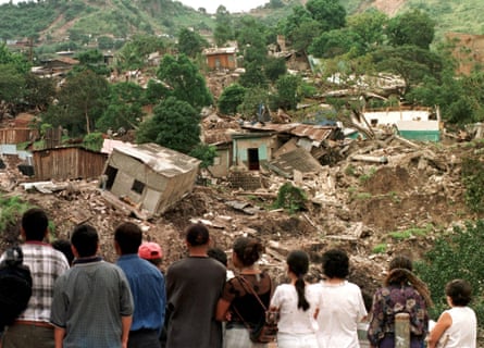 A group of people look at some of the homes destroyed by a mudslide