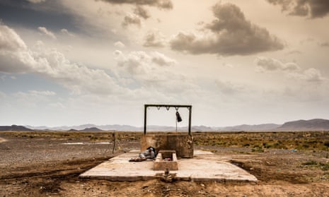 A man sleeps next to a well in the East Moroccan Sahara desert not far from the border with Algeria.