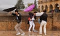 Tourists struggle to hold on to their umbrellas in Ronda