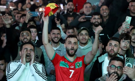 A group of mainly young men cheering th result of the game