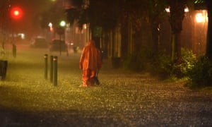 A communal worker braves the deluge in Charleston