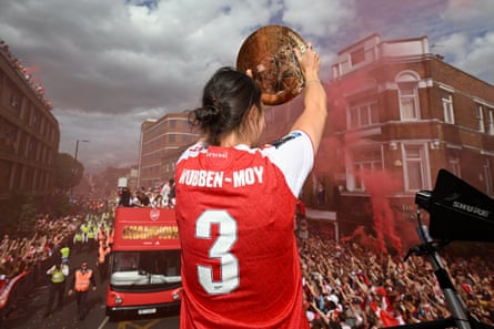 Lotte Wubben-Moy lifts the Champions Cup trophy on the open top bus during the Arsenal parade.