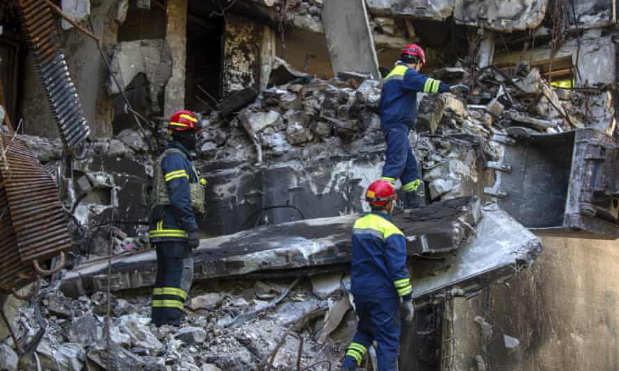 Ukrainian emergency service personnel work outside a damaged building following shelling, in Kharkiv, Ukraine.