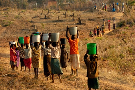 Girls and women begin the long haul back home from the water hole, Malawi