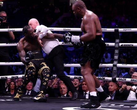 Referee Mark Bates attempts to pull apart Deontay Wilder and Derek Chisora.