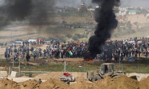 Black smoke rises while Palestinians protest on the Gaza side of the border with Israel.