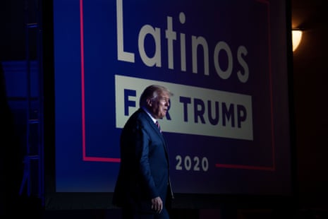 President Trump walks past a large screen reading "Latinos for Trump 2020"