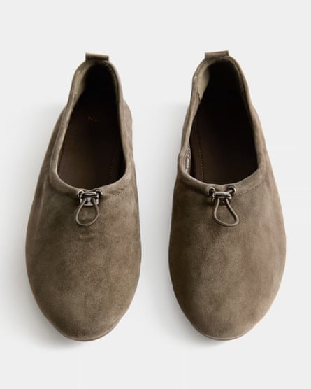 A pair or earth-coloured ballet pumps with a toggle cord at the front