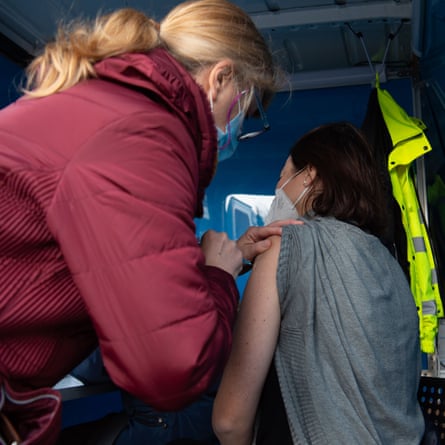 A woman receives a Covid jab at a mobile NHS vaccination centre in Gerrards Cross, Bucks.