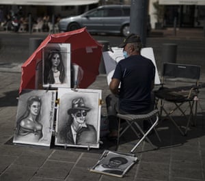 A street painter works in Marseille’s Old Port, southern France.