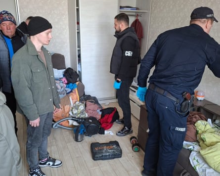 Police inspect Tymchenko’s bedroom as he looks on